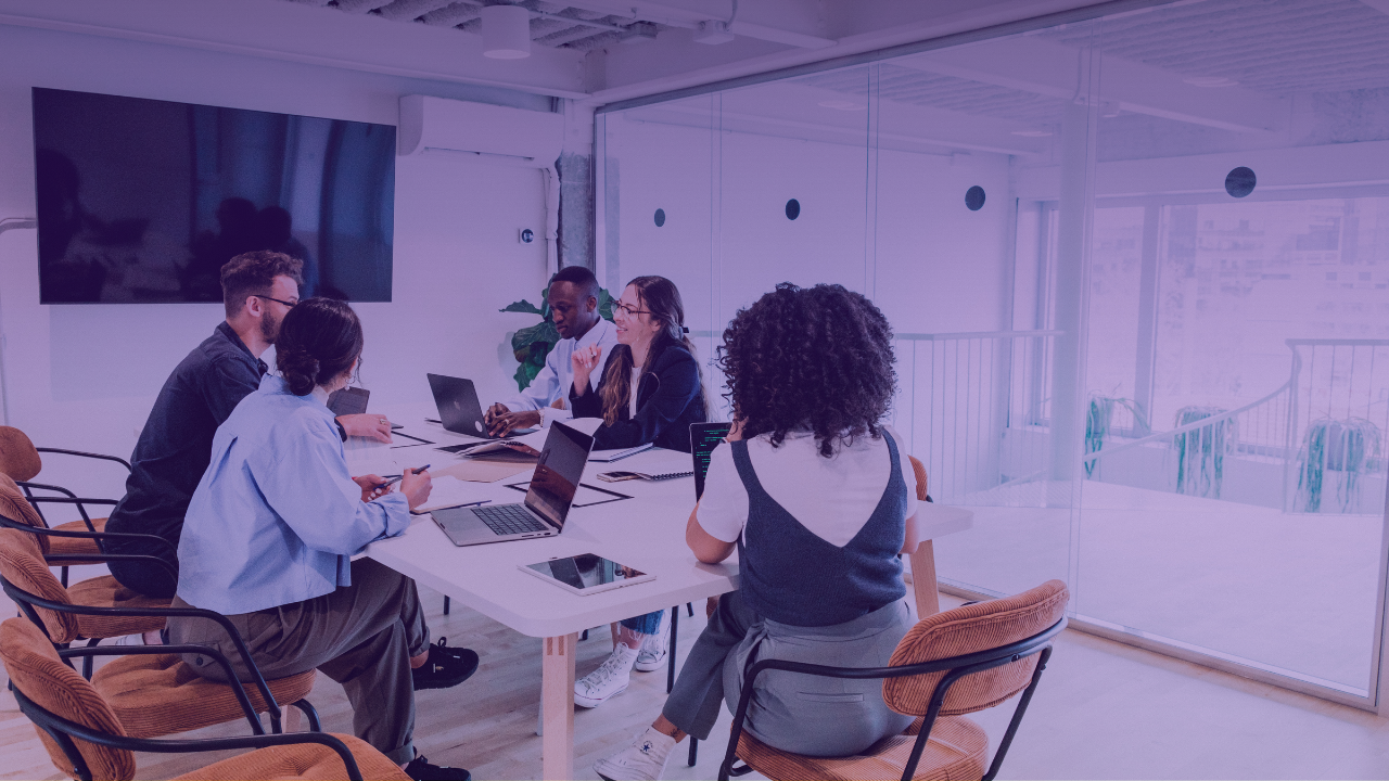 Un groupe échange autour d’une table avec des ordinateurs
